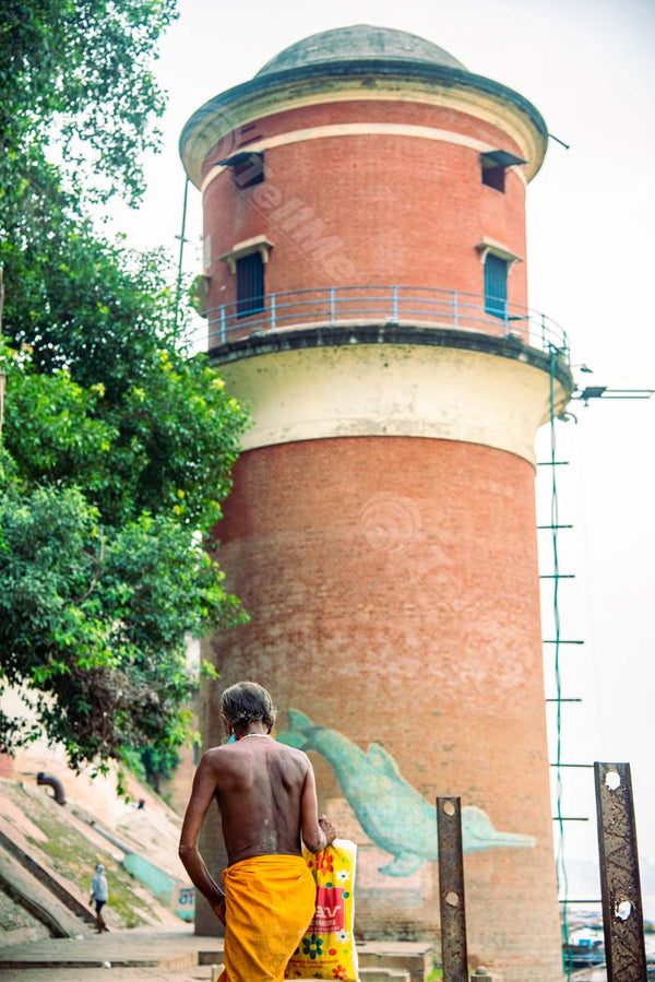 A Pilgrim Walks Past the Lighthouse at Assi Ghat, Banaras, Uttar Pradesh