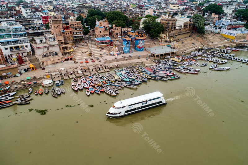 Riverside Serenade: Alaknanda Cruiseline Glides Amidst Moored Boats, Assi Ghat, and Varanasi's Enchanting Ghats in Uttar Pradesh