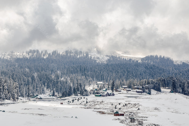 Snowy Vista: Mountains, Trees, and Resorts under Cloudy Skies in Gulmarg, Kashmir, India