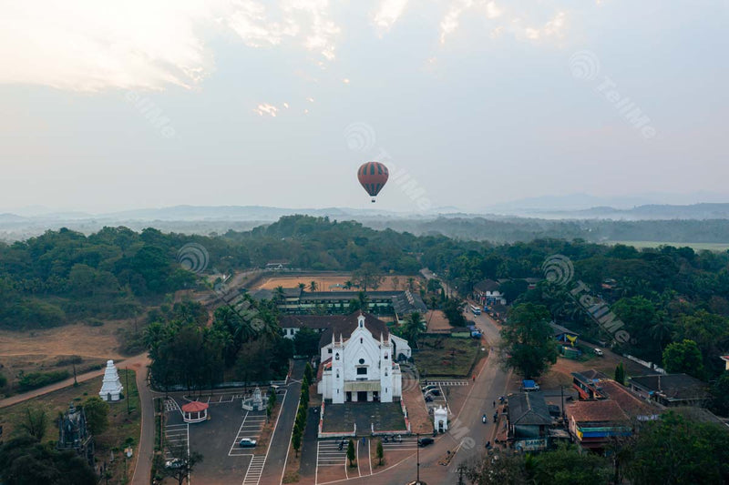 Aerial Symphony: Hot Air Balloon Soaring Through Goa's Cathedral Amidst Nature's Splendor