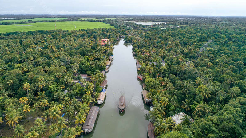 Aerial Marvel: Kumarakom Backwaters' Serene Vistas - Vembanad Lake, Floating Boat, Coconut Trees, and Village in Kerala
