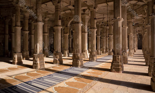 Sunlit view of pillars of the mosque inside Sarkhej Roza Dargah in Ahmedabad, Gujarat